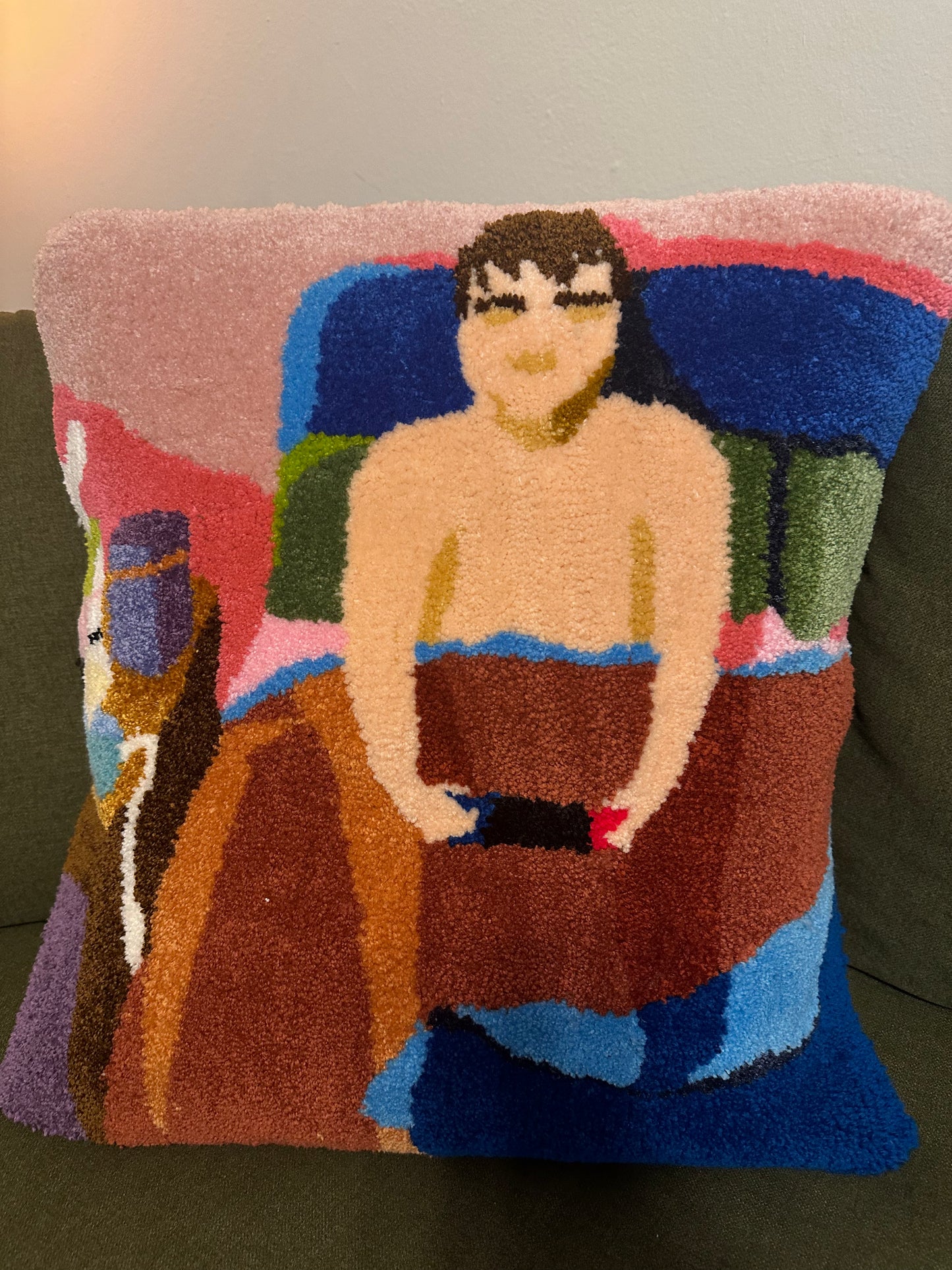 decorative pillow with a stylized depiction of a person sitting in bed, playing video games by lamplight