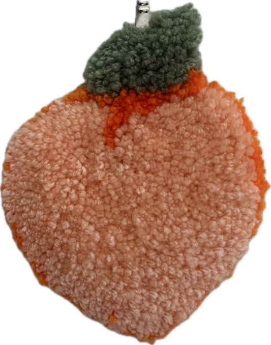 Tufted peach with a green leaf on a white background