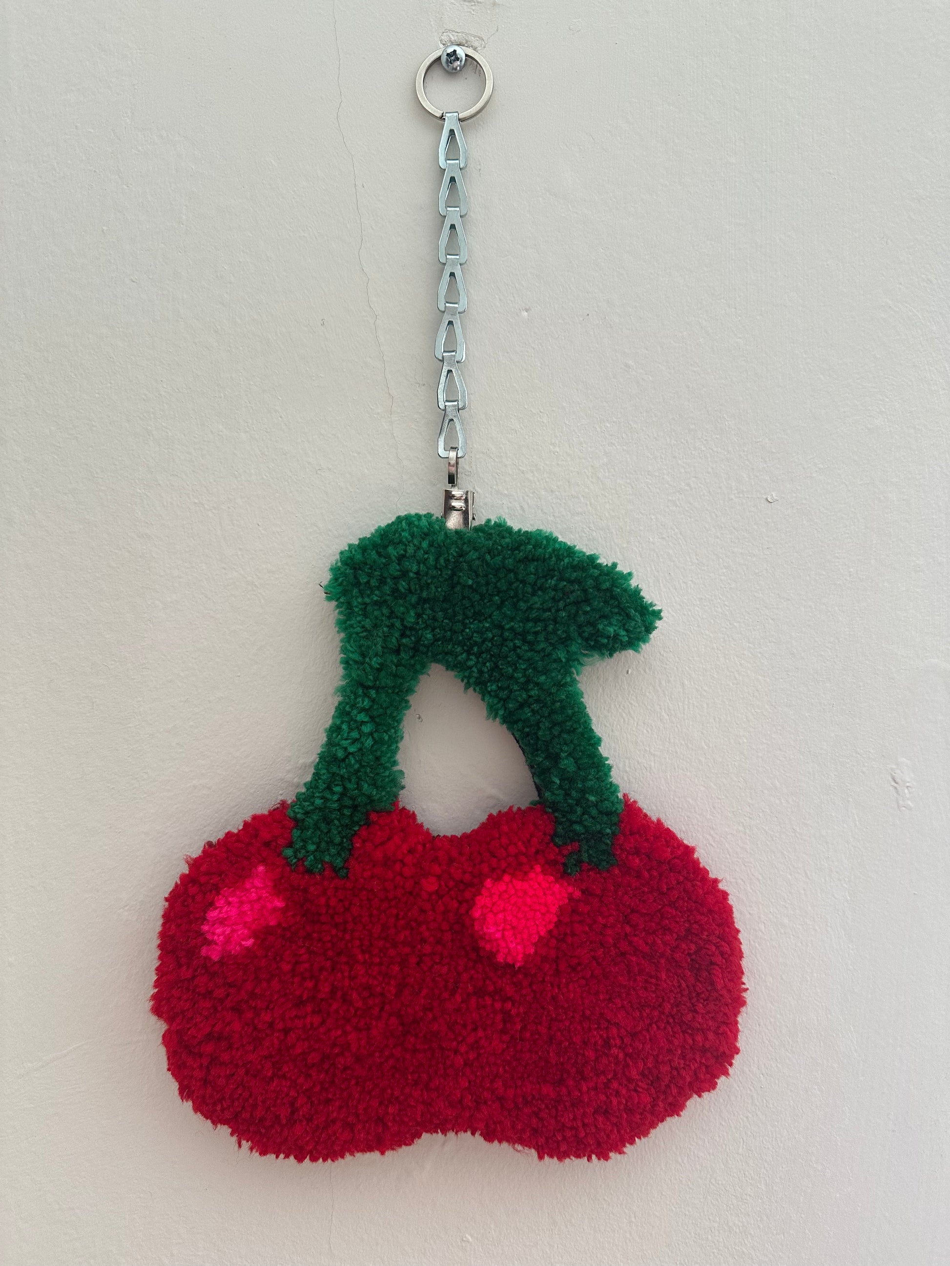 cherry rug hung on a wall via chain