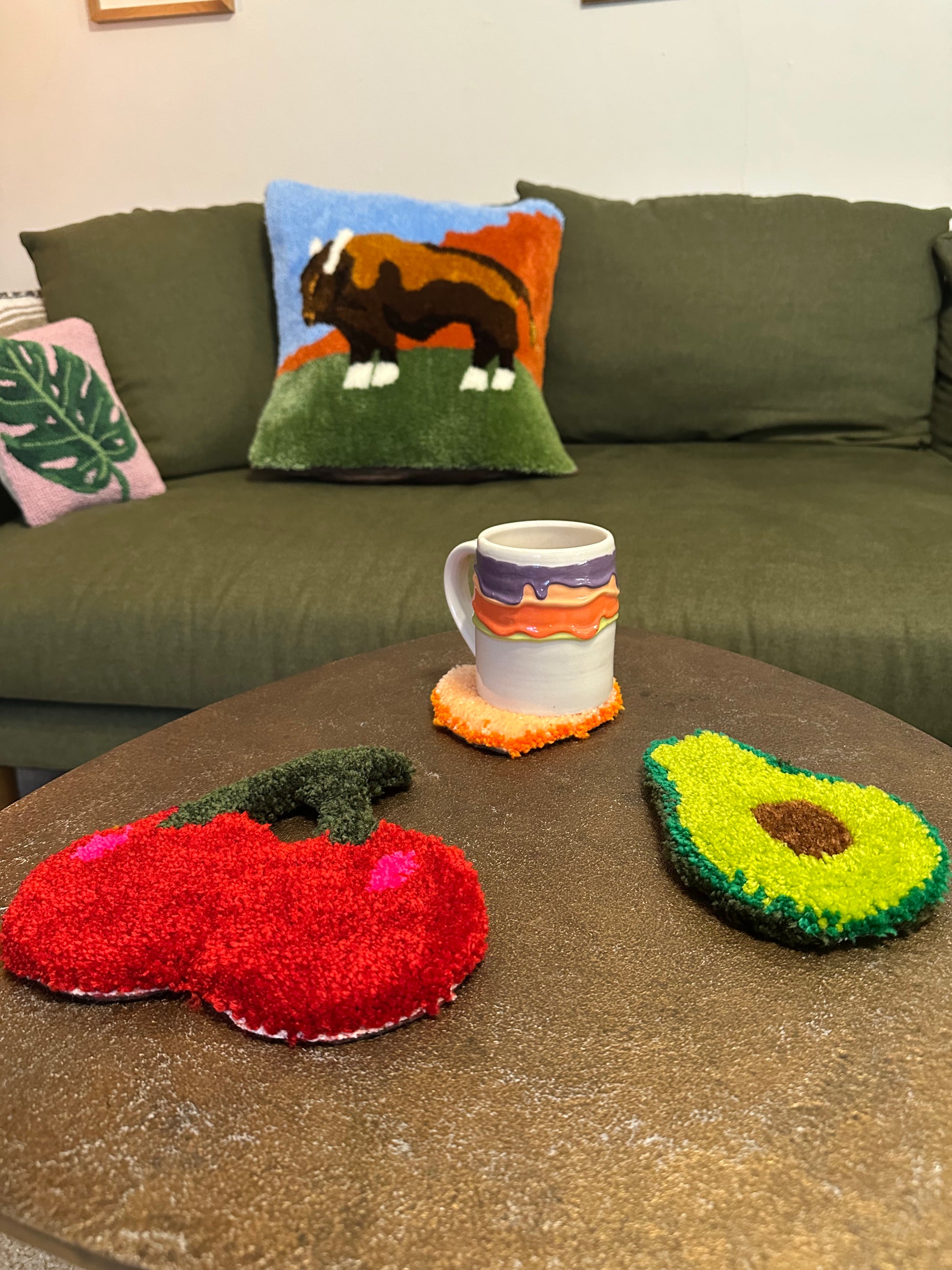 Decorative tufted coasters on a table with a mug resting on top